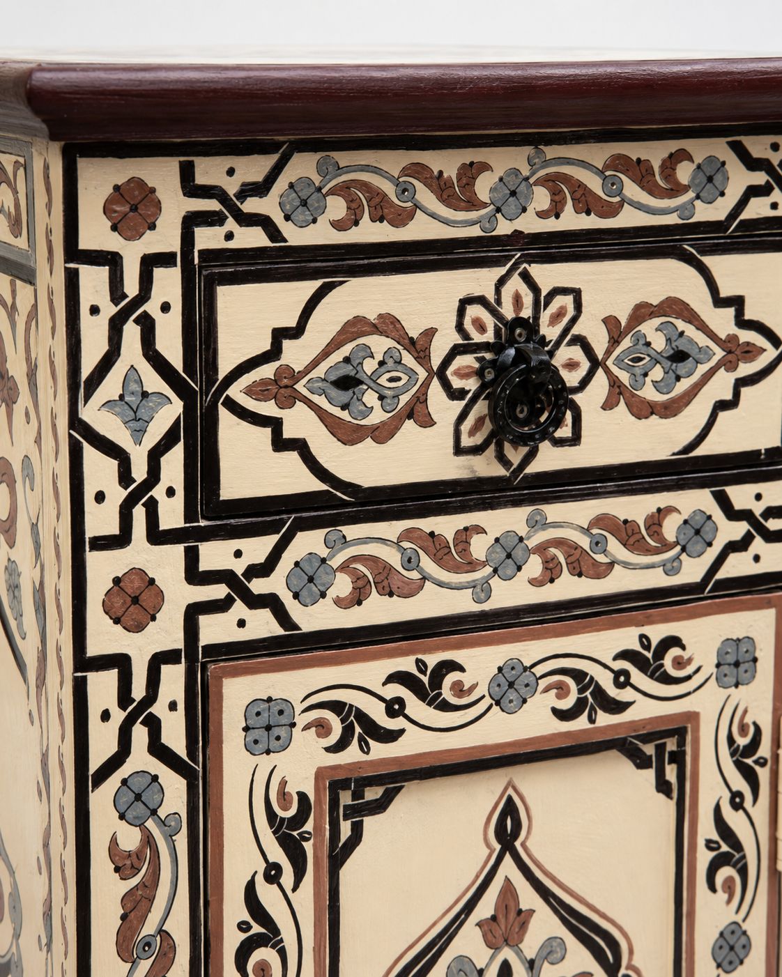 Decorative wooden drawer with intricate patterns and a black handle.