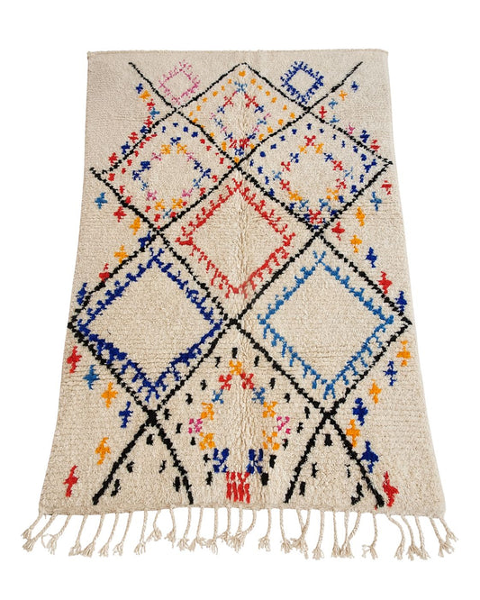 Handmade Moroccan wool rug with colorful overlapping diamonds on a cream background. 