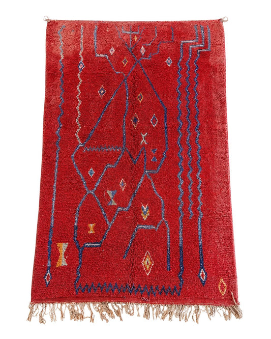 Red handmade Moroccan rug with dark blue abstract lines and geometric motifs. 