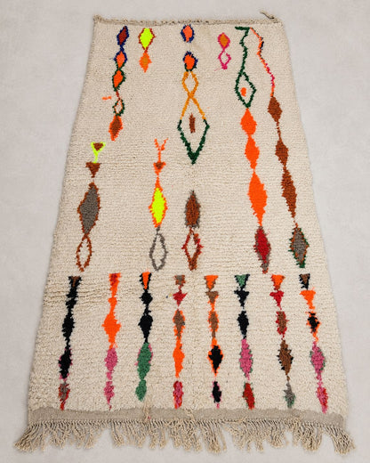 Front view of a rectangular cream rug with irregular geometric designs. 