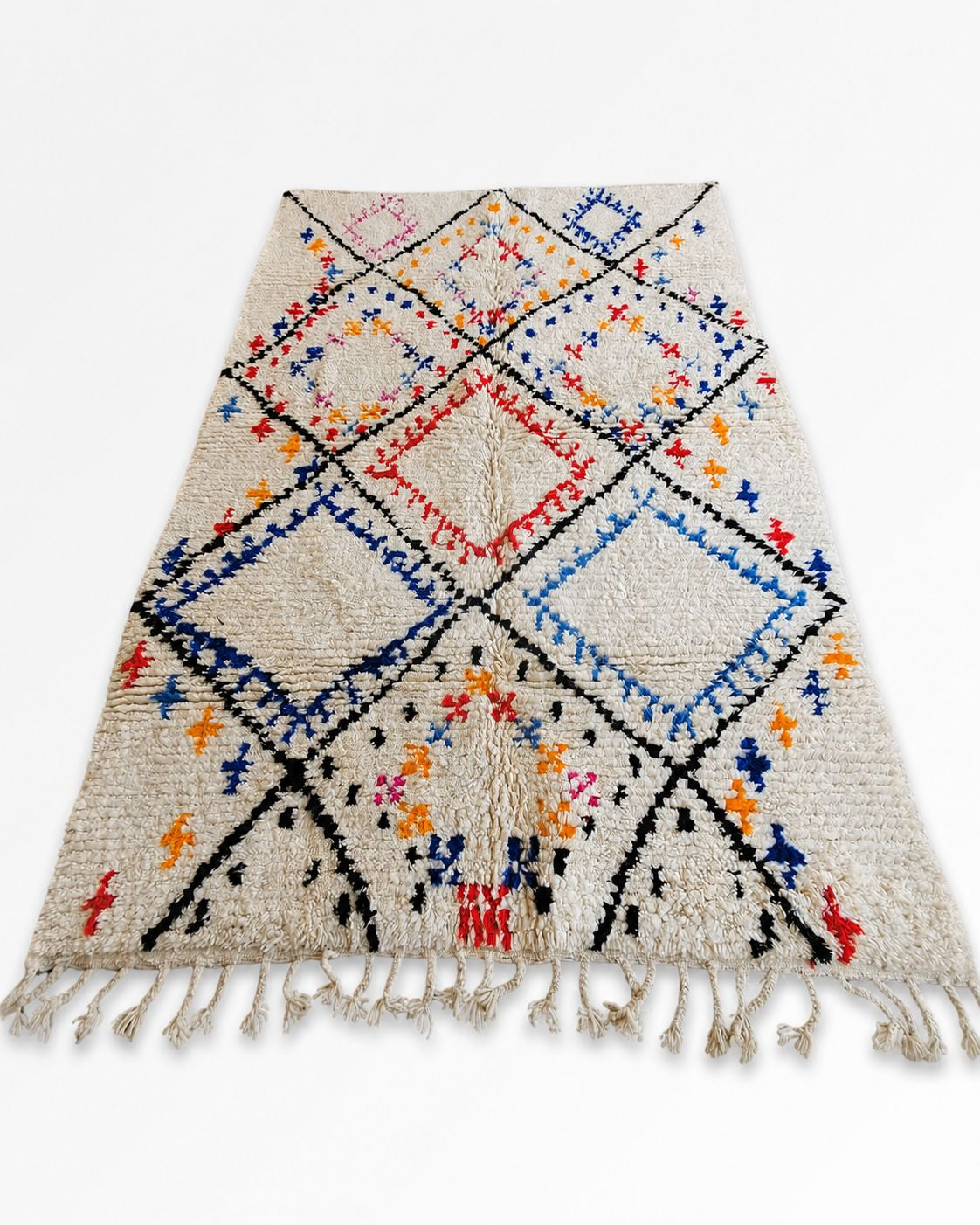 Hand-finished cream tassel fringe along the Moroccan rug’s short edge. 
