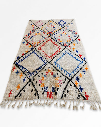 Hand-finished cream tassel fringe along the Moroccan rug’s short edge. 