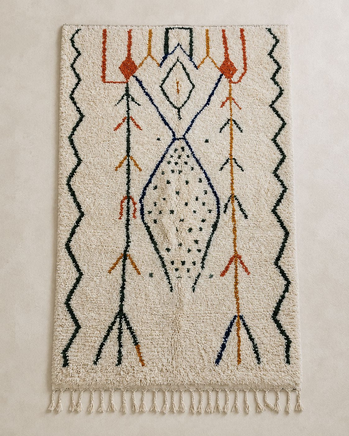 A symmetrical, top-down flat view of the geometric lines and orange accents on the ivory Moroccan wool rug.