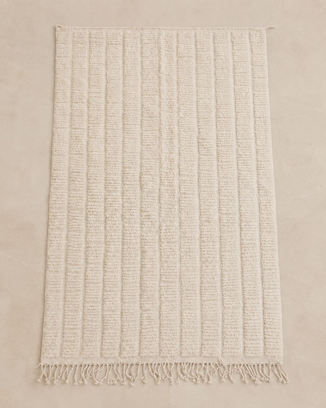 A full-length front view showcasing the parallel linear patterns and neutral ivory tones of the Moroccan wool rug.