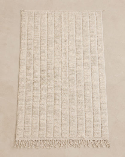 A full-length front view showcasing the parallel linear patterns and neutral ivory tones of the Moroccan wool rug.