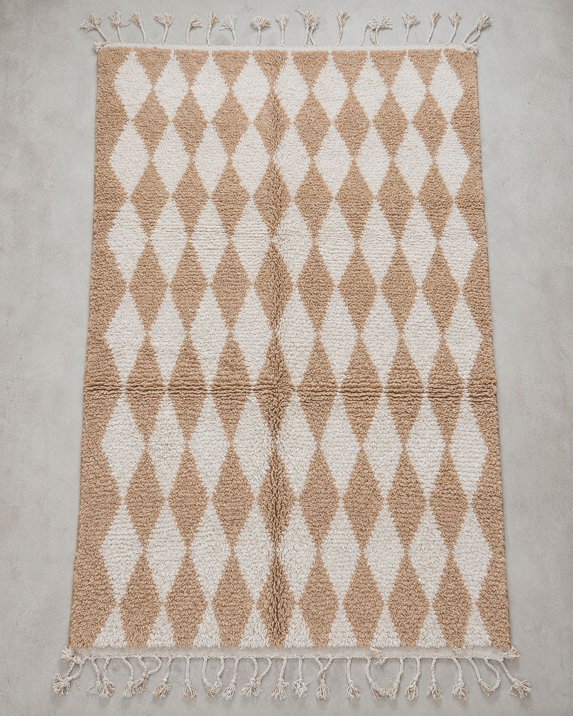Close-up of the textured wool surface and beige and ivory pattern. 