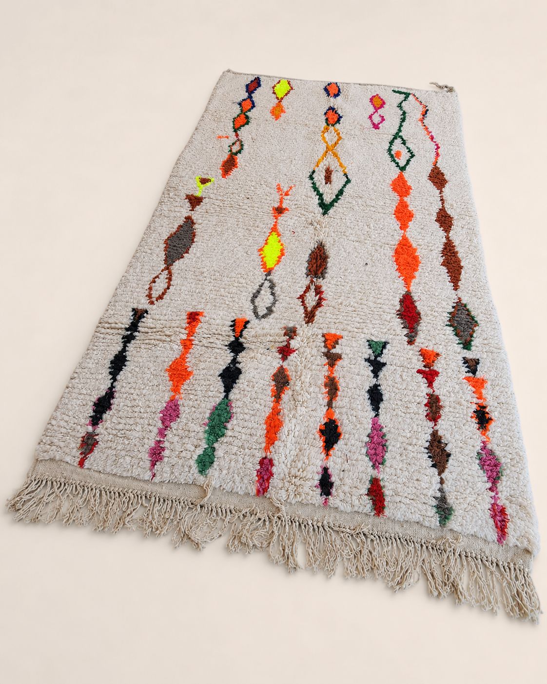Close-up of the rug’s textured surface and colorful handmade motifs. 