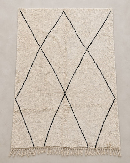 Front view of a cream Moroccan rug with large irregular black diamonds. 