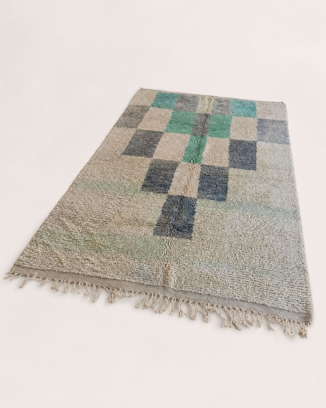 Back view showing the handmade construction and aged finishing of the wool rug. 