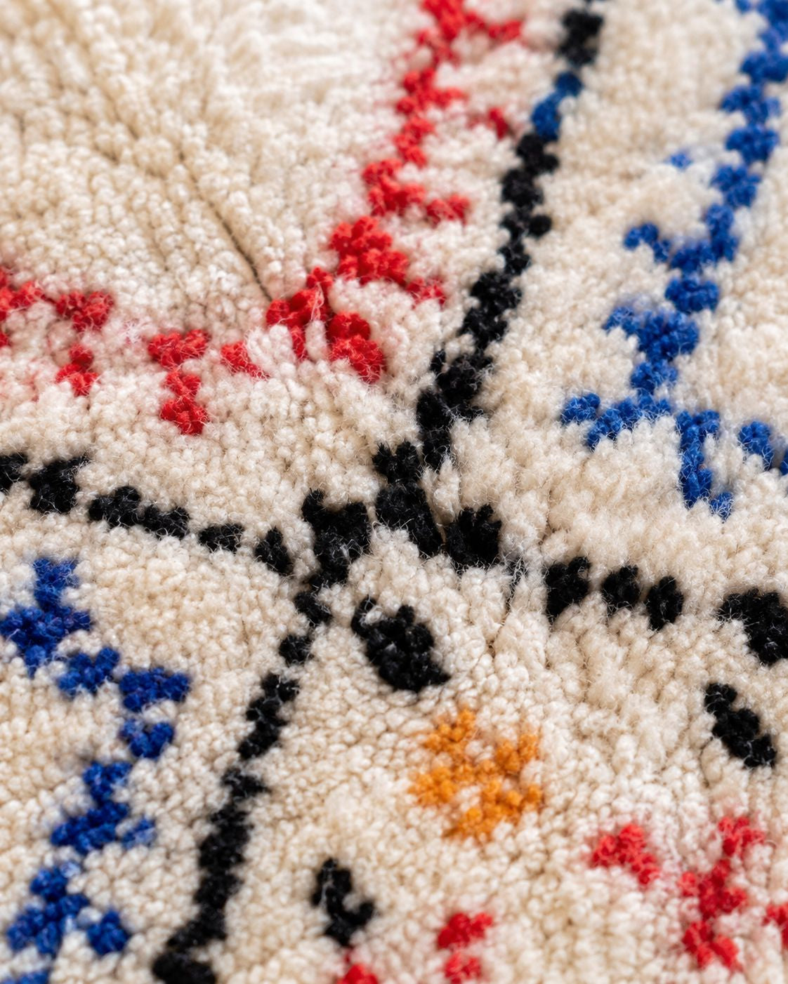Close-up of the textured wool pile and colorful geometric detailing. 