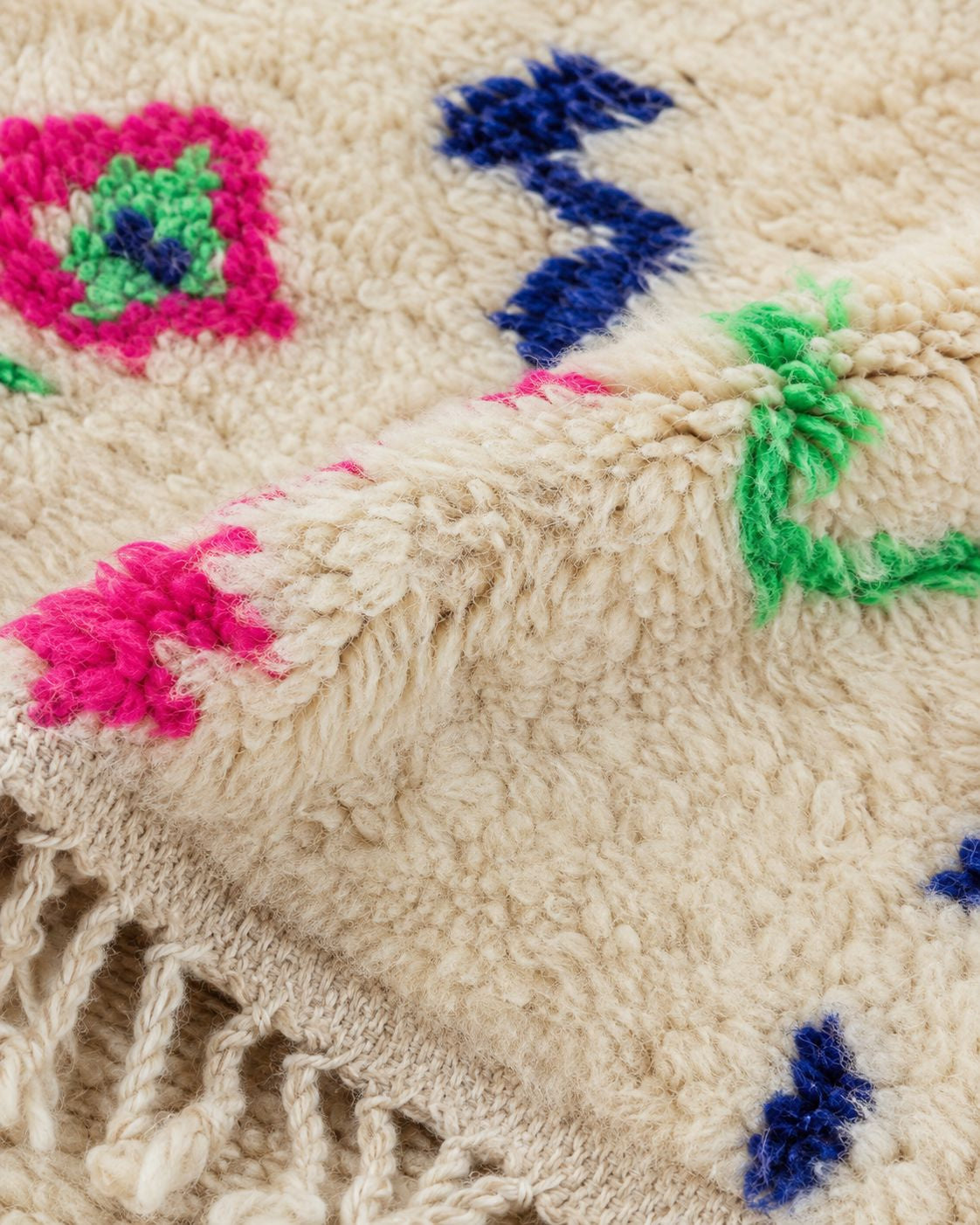 Hand-tied ivory fringe and colorful patterned edge of the Moroccan rug. 