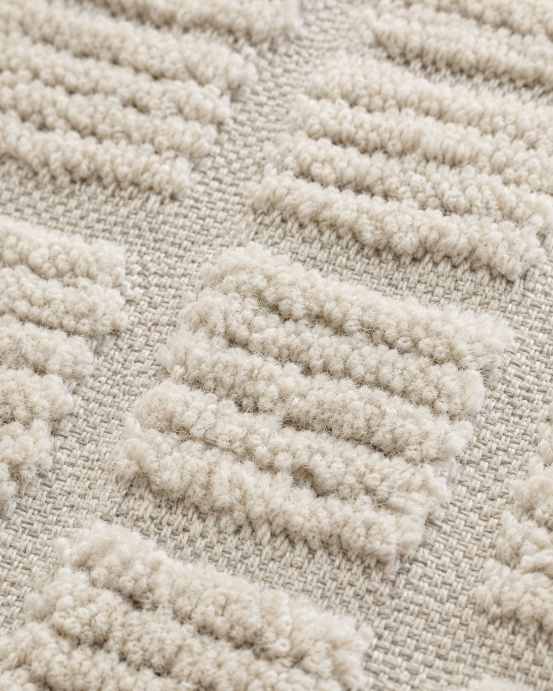 A close-up view focusing on the twisted off-white tassels finished neatly on one end of the linear Moroccan rug.