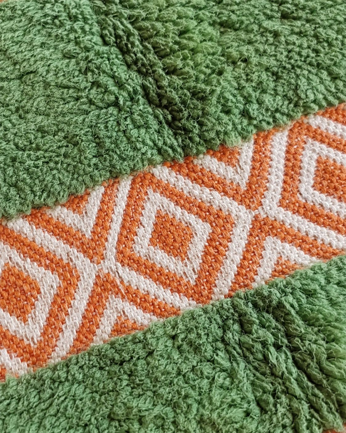 Close-up of the textured green surface and terracotta woven detailing. 