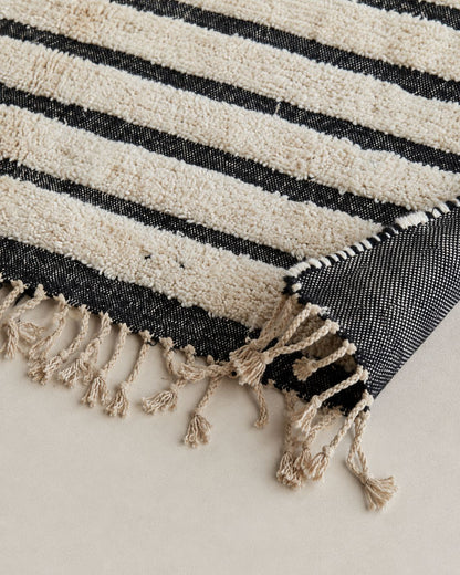 Cream tassel fringe along the short edge of the Moroccan wool rug. 