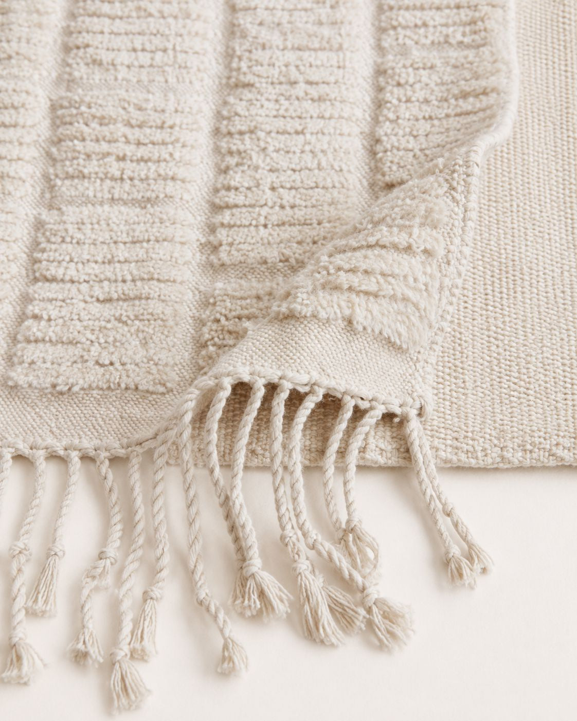 A detailed close-up shot of the high-low pile structure and plush 100% wool material of the handmade rug.