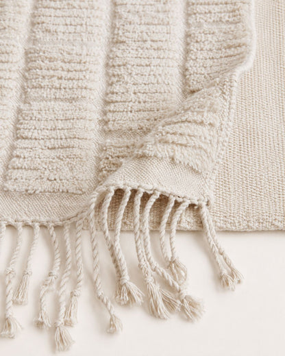 A detailed close-up shot of the high-low pile structure and plush 100% wool material of the handmade rug.