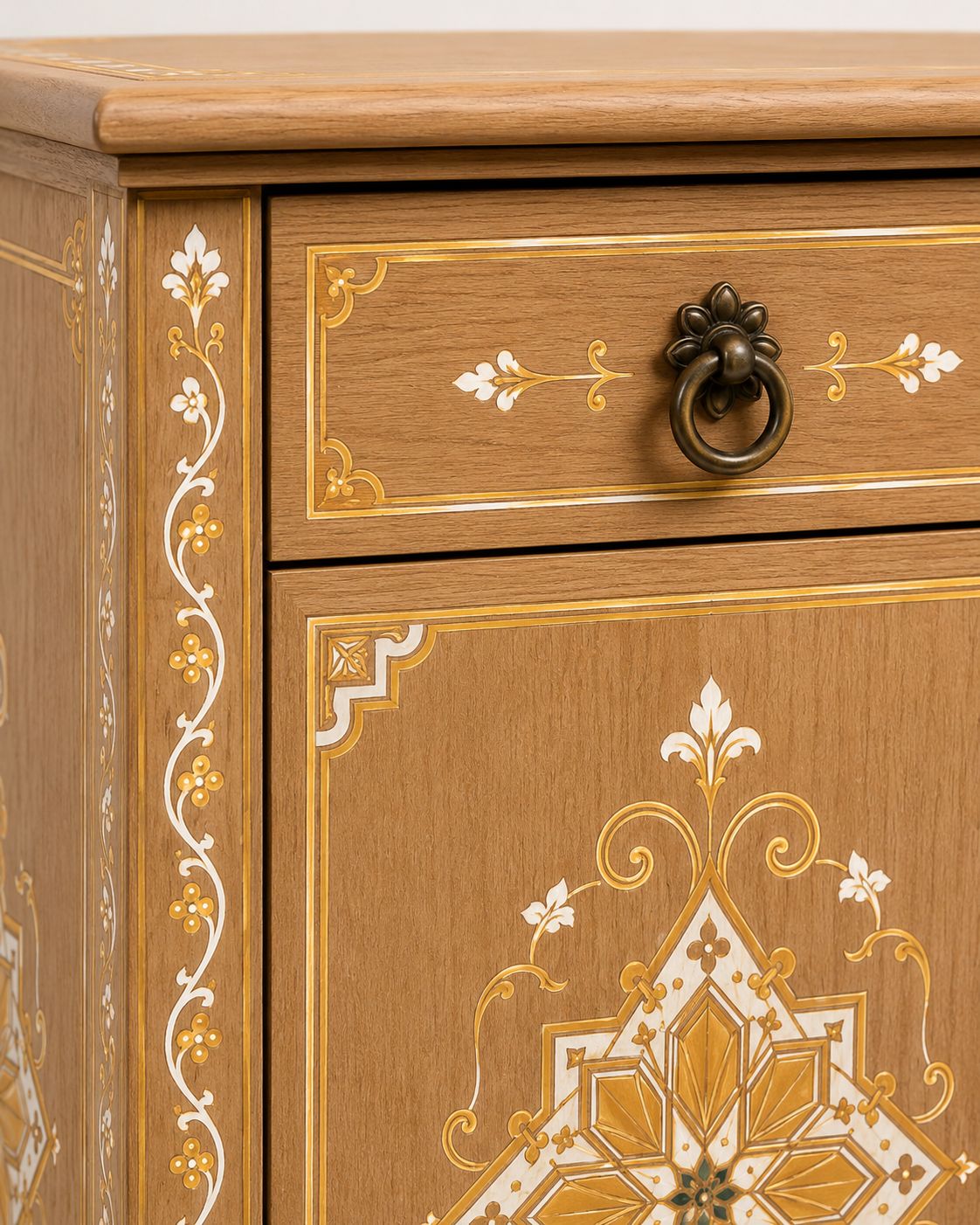 Wooden drawer with decorative gold and white patterns on a wooden cabinet.