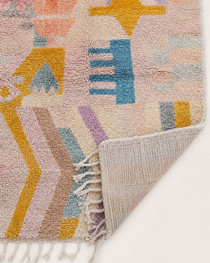 Cream tassel fringe along the edge of the handmade Moroccan rug. 