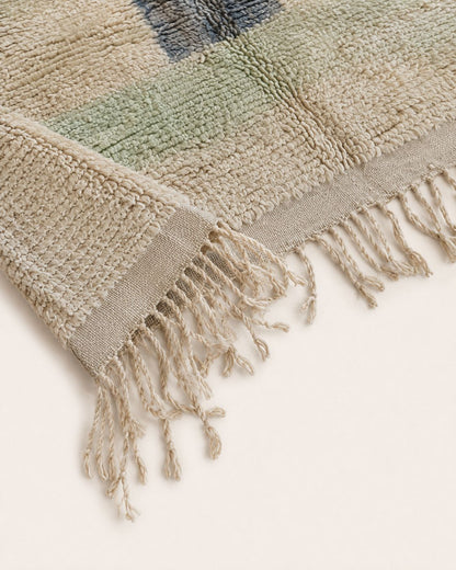 Cream tassel fringe along the edge of the vintage Moroccan rug. 