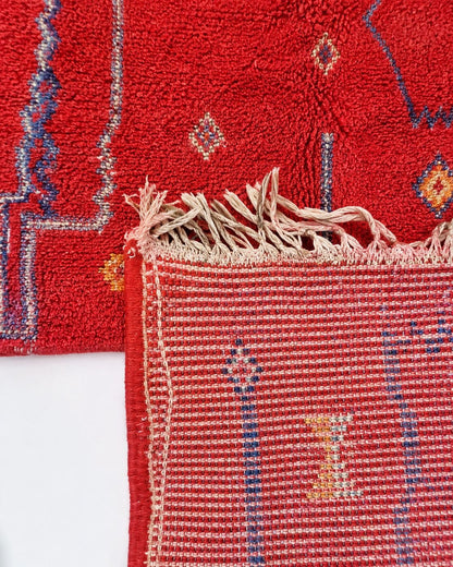 Cream tassel fringe along the short edge of the Moroccan rug. 