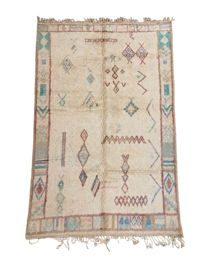 Vintage ivory Moroccan rug with faded pastel geometric motifs and tassel fringe. 