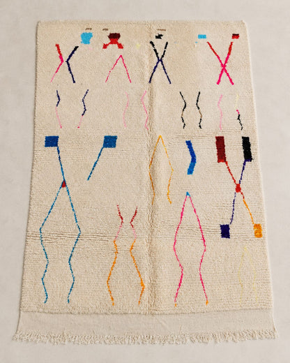 Front view of an ivory wool rug with pink, blue, red, and orange linear symbols. 