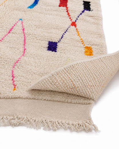 Short cream fringe and finished edge of the handmade Moroccan rug. 