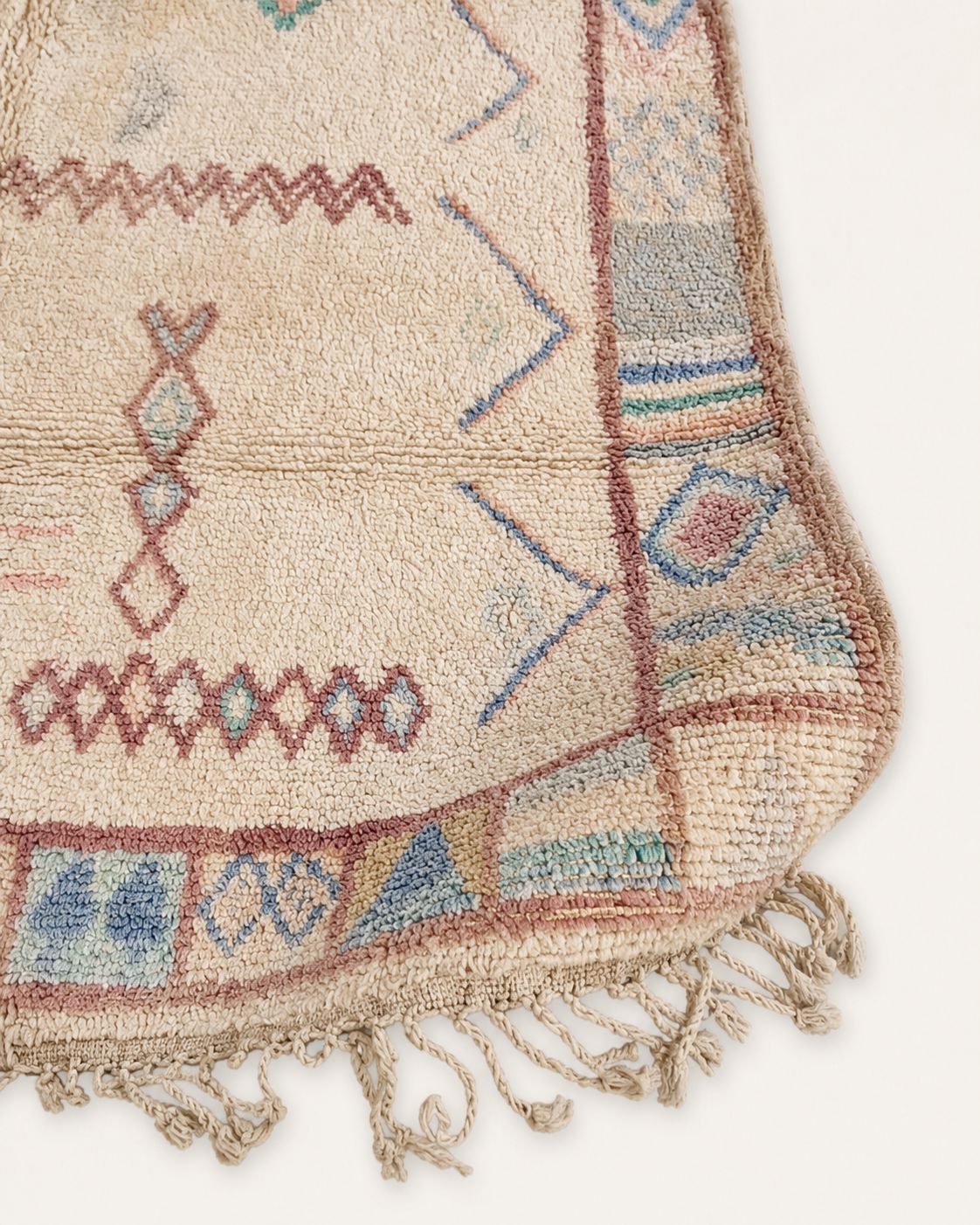 Handmade tassel fringe and bordered edge of the vintage Moroccan rug. 
