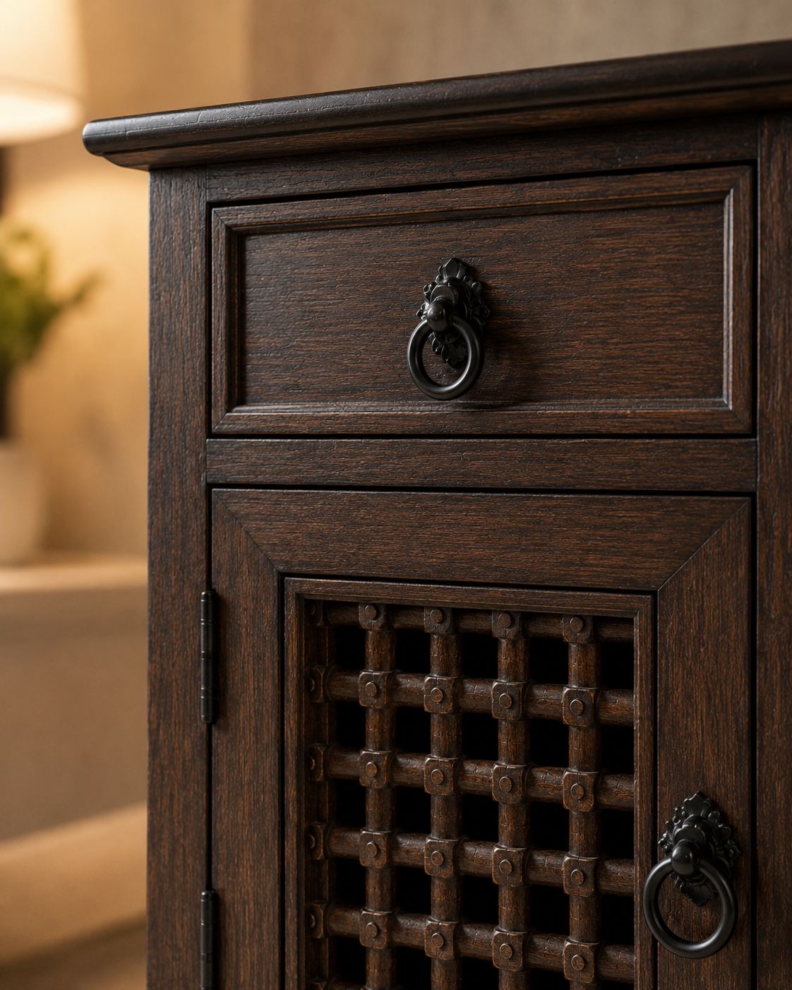 Dark wooden cabinet with decorative grille and lion head handles on a blurred background
