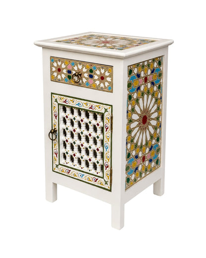 White boho nightstand beside bed with lamp and plant decor 