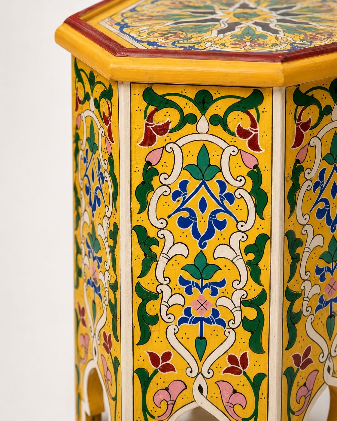 Top-down view of an octagonal wooden side table showcasing a symmetrical hand-painted mandala pattern.